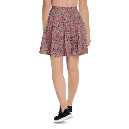A person wearing a red and black Mambí floral-patterned flared skirt and black sneakers, seen from the back against a plain white background.
