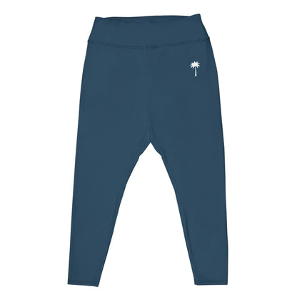 Dark teal high-waisted Mambí leggings with a small white palm tree graphic on the left hip, displayed flat on a white background.