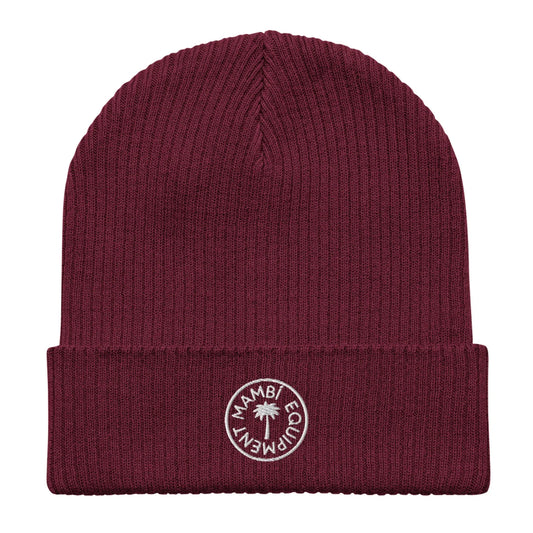 A maroon ribbed knit beanie with a folded brim, featuring a circular white embroidered patch that says Mambí Equipment and displays a small palm tree in the center.