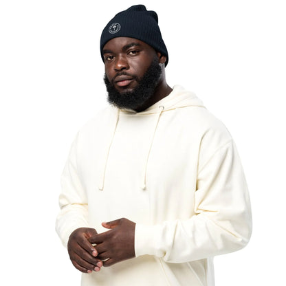 Man in ivory hoodie wearing navy ribbed organic unisex beanie on white background