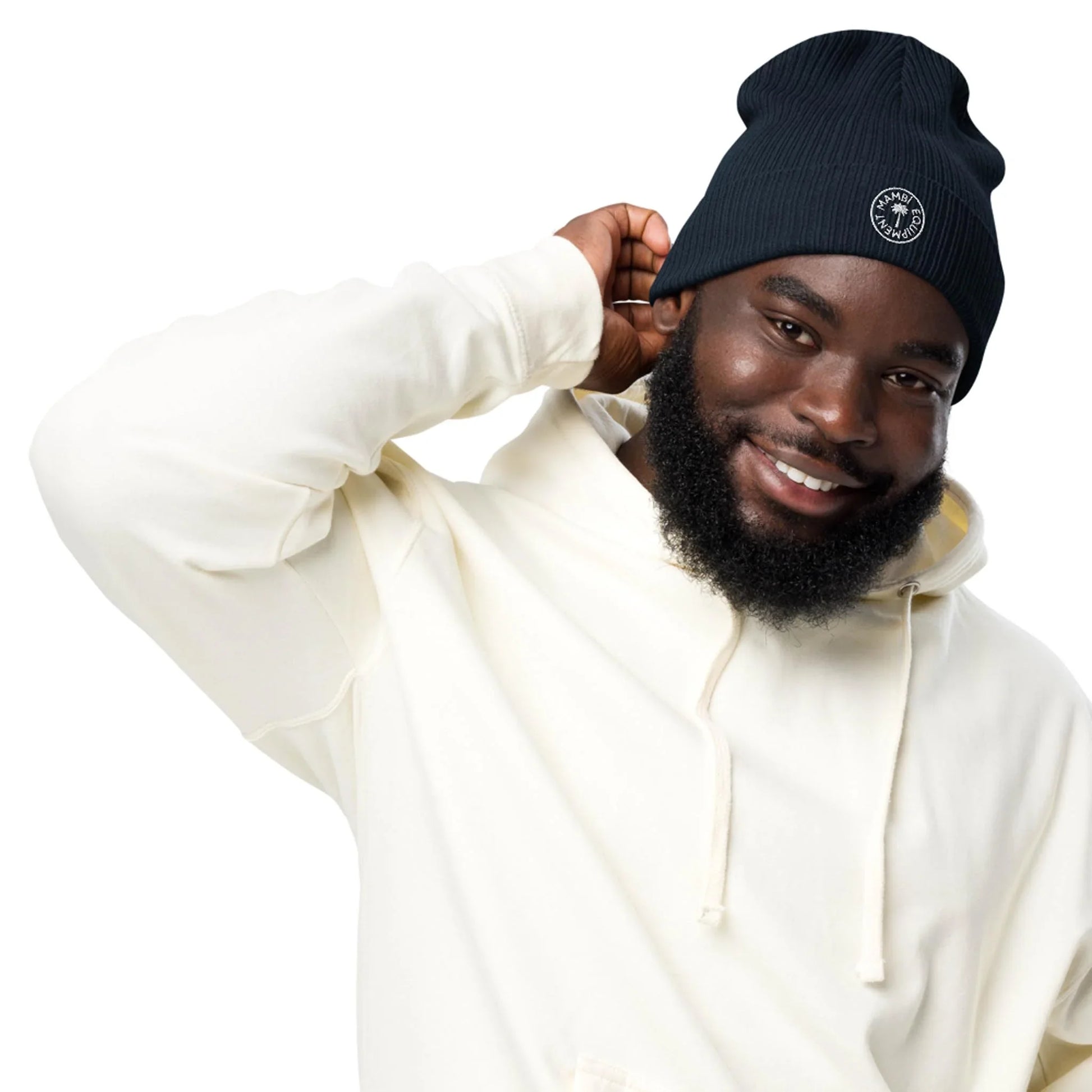 Man wearing navy ribbed organic beanie and ivory hoodie, smiling, studio white background
