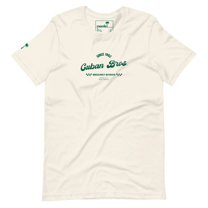 The Cuban Bros Graphic Tee by Printful features green Since 1982 Cuban Bros. Brotherhood Athletic New Jersey text on off-white, a palm tree icon on the sleeve, and a classic crew neck style—perfect for entrepreneurs. Unisex fit.
