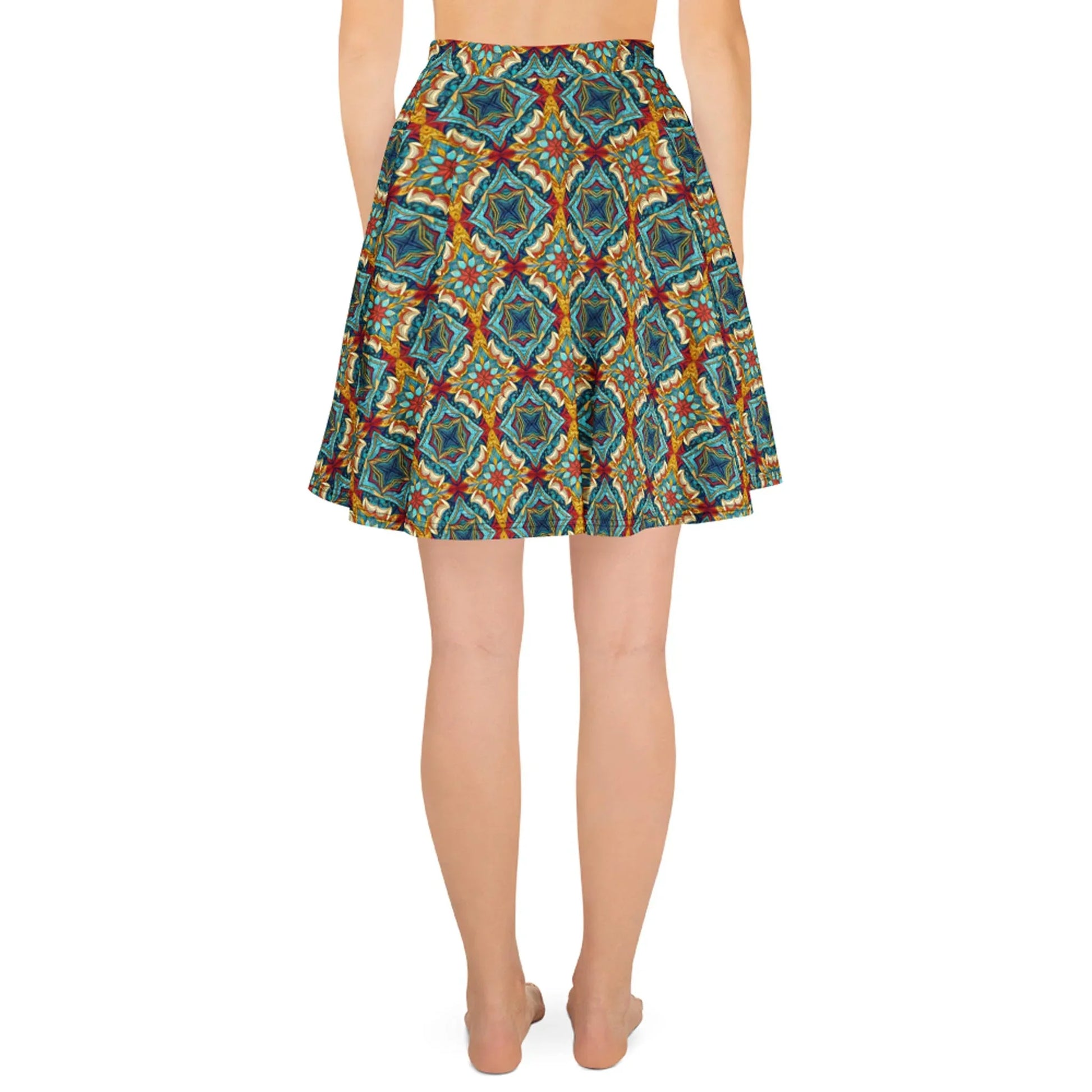 A person stands barefoot, facing away from the camera, wearing Printful’s Dinorah Skater Skirt—a knee-length women’s skirt with a geometric and floral pattern in blue, green, orange, and red, featuring an elastic waistband for a flattering fit.