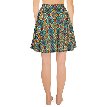 A person stands barefoot, facing away from the camera, wearing Printful’s Dinorah Skater Skirt—a knee-length women’s skirt with a geometric and floral pattern in blue, green, orange, and red, featuring an elastic waistband for a flattering fit.