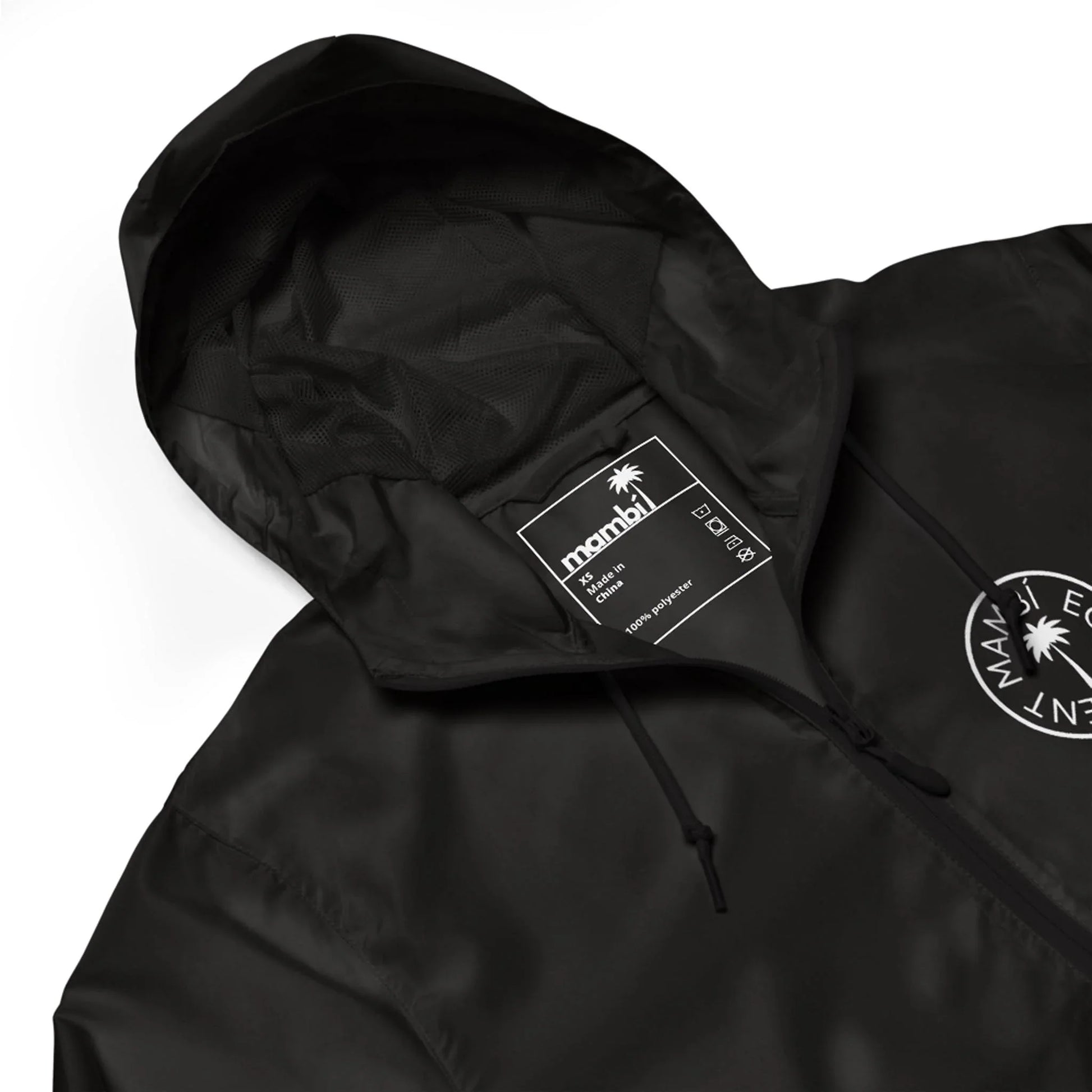 A black hooded jacket with a drawstring, featuring a circular white Maui Element logo on the chest, a visible inner label with product details, and Mambí-inspired style.