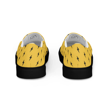 The Electra Handmade Slip-On Canvas Shoes by Printful feature a bold yellow canvas with black lightning bolt pattern, black soles, and are shown from the back—perfect for making a striking fashion statement.