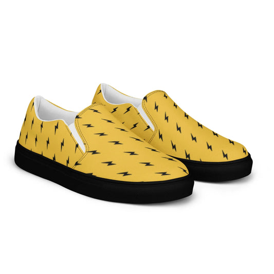 The Electra Handmade Slip-On Canvas Shoes for men by Printful feature yellow canvas with small black lightning bolts, black soles, and are shown on a white background.