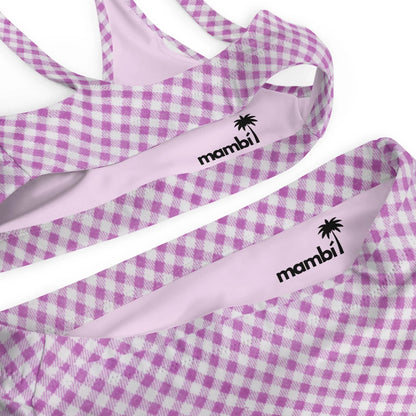 Close-up of a swimsuit with a lavender and white gingham pattern. The light pink inner lining features the word Mambí alongside a palm tree logo printed in black.