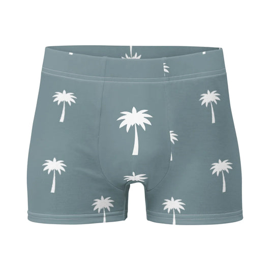 The Emerson Boxer Brief by Printful features a blue-gray base with white palm tree patterns and offers a seamless fit for all-day comfort.