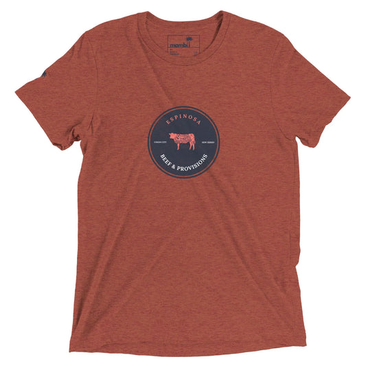 A heathered rust-colored Mambí t-shirt with a circular navy logo in the center featuring a cow illustration and the text ESPINOSA BEEF & PROVISIONS, along with Texas Born and Family Raised.