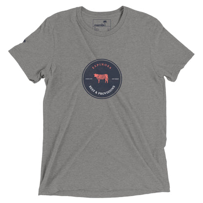 A heather gray t-shirt with a circular navy blue logo in the center reading Espinosa Beer & Provisions and featuring a red cow illustration. The brand name Mambí is printed inside the collar.
