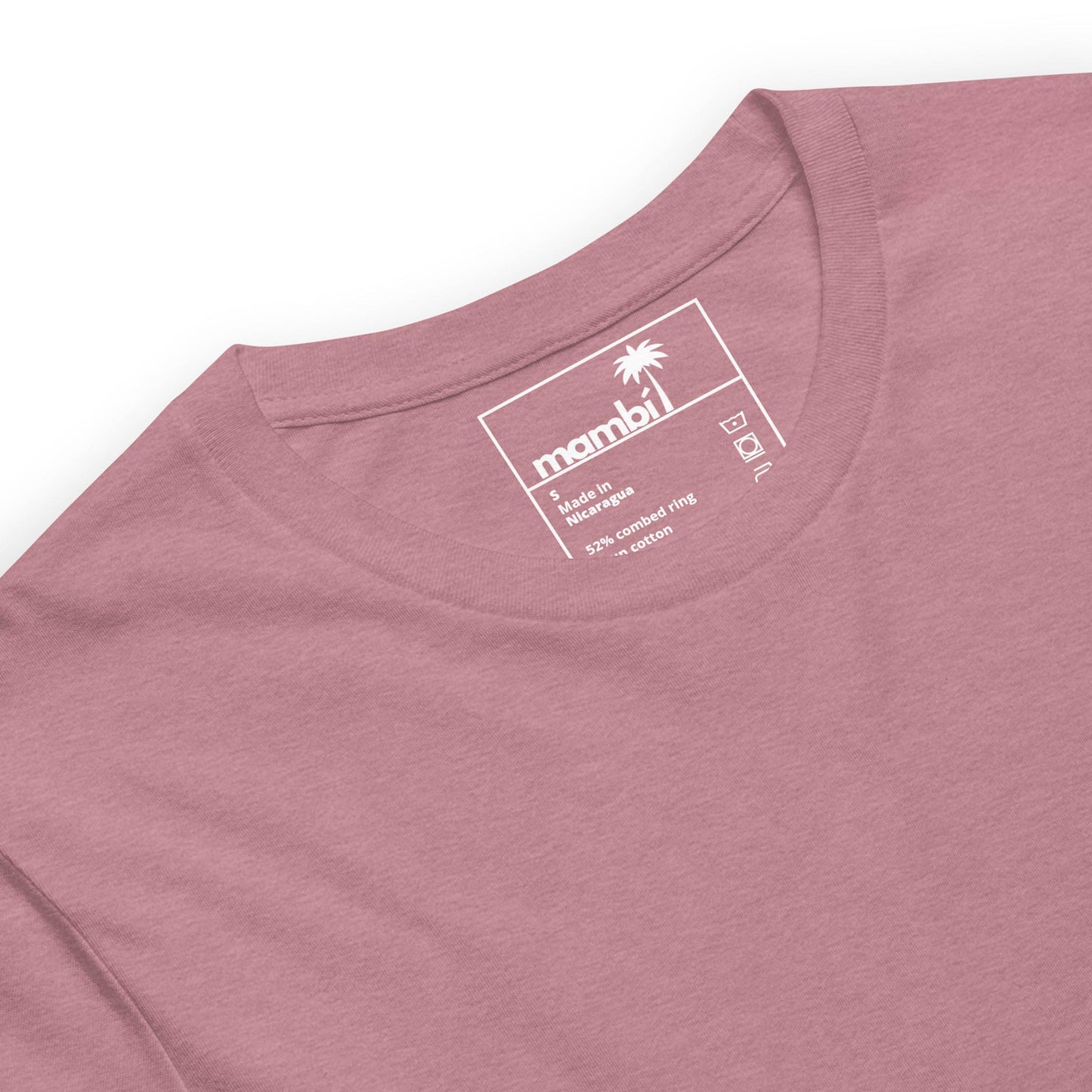 A close-up of a dusty pink t-shirt with a round neckline. The inner label displays the Mambí brand with a palm tree logo, size L, and fabric details: 52% combed cotton, 48% polyester.