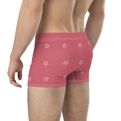 A person wearing pink Mambí boxer briefs with a white star pattern is shown from the back, with their upper back, waist, and upper legs visible.