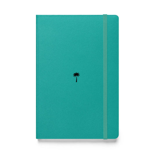 A teal-colored Mambí notebook features a small black palm tree icon in the center and an elastic band closure running vertically along the right side.