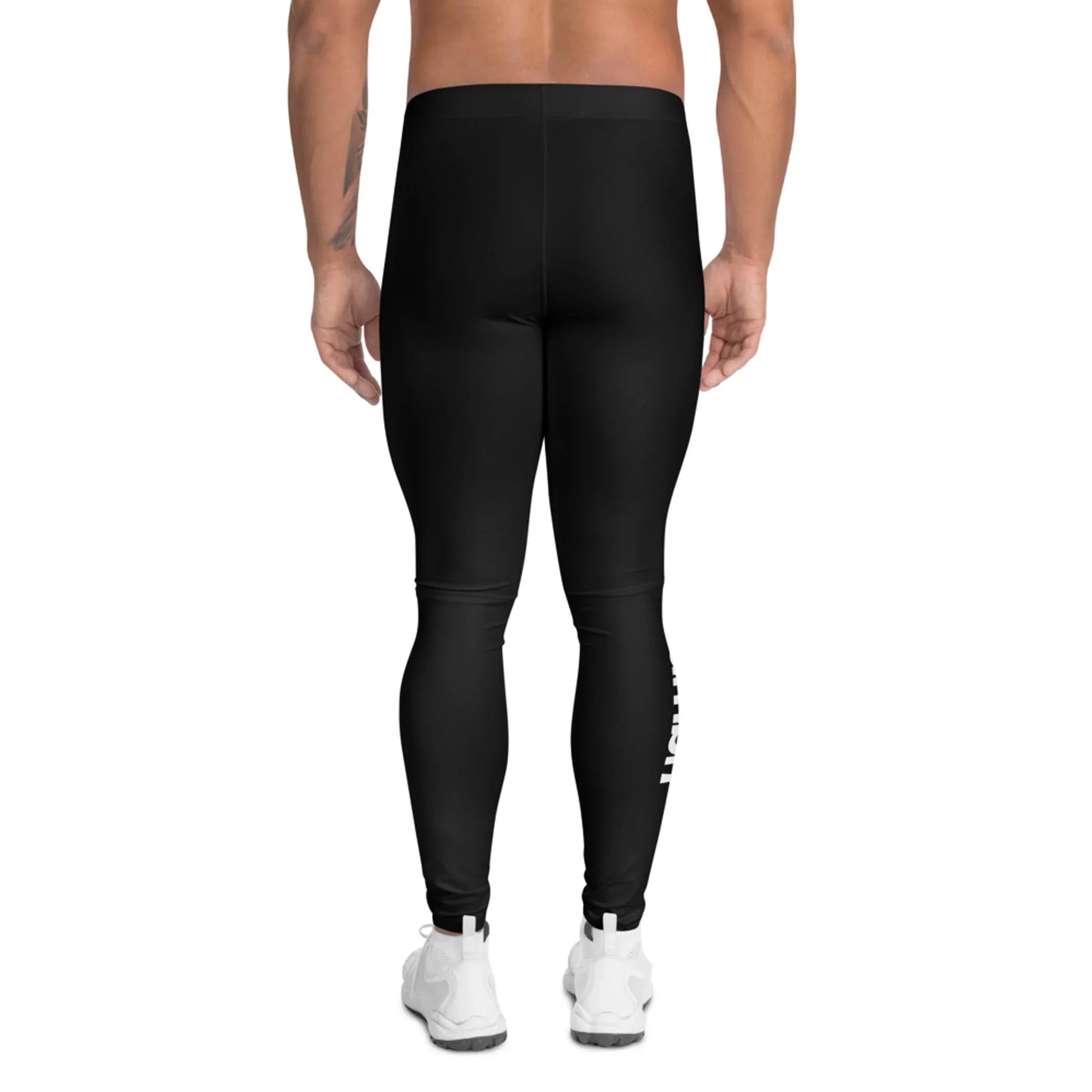 A person stands with their back to the camera, wearing Mambí black leggings and white athletic shoes against a plain white background.