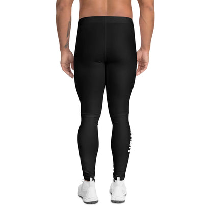 A person stands with their back to the camera, wearing Mambí black leggings and white athletic shoes against a plain white background.