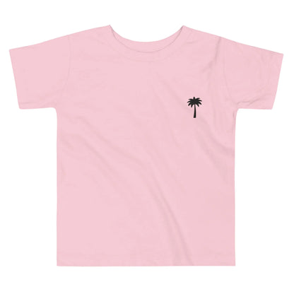 Light pink Mambí t-shirt featuring a small, simple black palm tree graphic on the left chest area. Shirt is laid flat on a white background.
