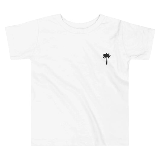 White t-shirt featuring a small black palm tree graphic on the left chest area. This minimal design captures a relaxed, Mambí-inspired vibe.