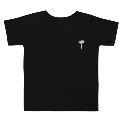 A plain black short-sleeve Mambí t-shirt featuring a small white palm tree graphic on the left chest area.
