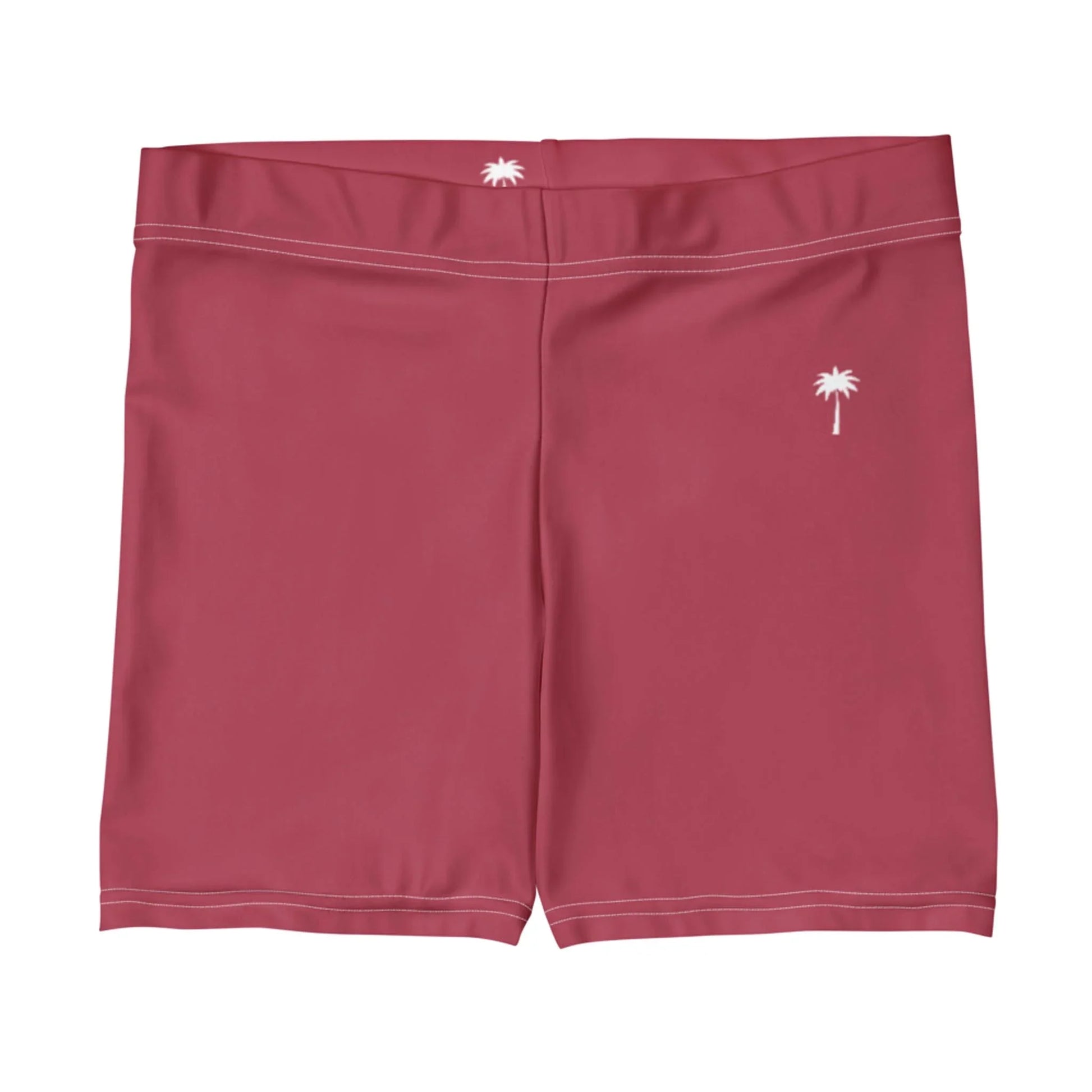 A pair of plain pink Mambí swim trunks featuring a small white palm tree graphic on the front left side and another on the back waistband.