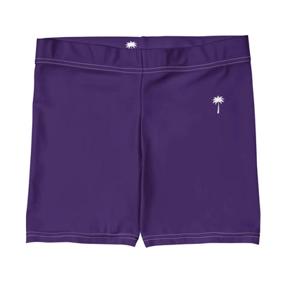 A pair of purple Mambí swim trunks with white stitching and small white palm tree logos on the front left leg and center back of the waistband.