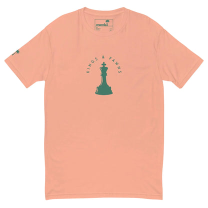 Peach-colored Mambí t-shirt featuring a green chess king piece at the center, with KINGS & PAWNS in a semicircle above and below. A small green palm tree decorates the left sleeve.