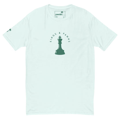 Light blue Mambí t-shirt featuring a green chess king piece graphic in the center, surrounded by the words “KINGS & PAWNS.” A small palm tree accents the left sleeve.