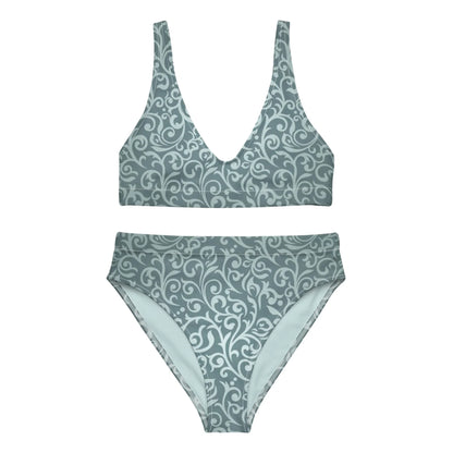 The Laurelia High-Waisted Bikini Swimsuit for women by Printful is a muted teal set with a deep V-neck top, removable pads, and matching bottoms, both featuring an elegant light swirl and floral pattern.