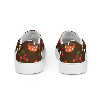 The Mario Handmade Slip-On Canvas Shoes for men by Printful feature a brown background with vibrant orange mushrooms, red berries, and floral patterns. Viewed from the back, they have white soles and lining—stylish and eye-catching.
