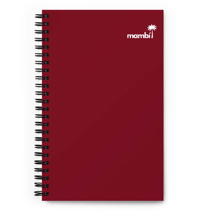 A maroon spiral notebook with a small white palm tree and the word “mambi” in the top right corner of the cover, perfect as a custom wire-bound notebook or a stylish dotted paper notebook for your notes.