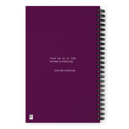 A purple wire-bound notebook with the quote What we do in life echoes in eternity. Marcus Aurelius printed in white text at the center.