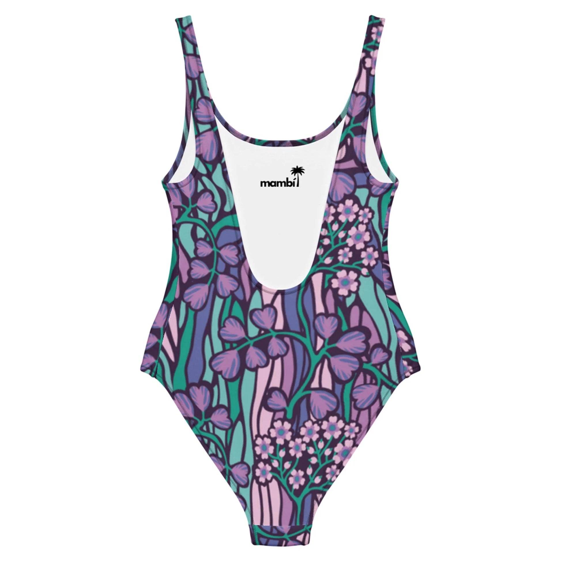 The Micaela One-Piece Swimsuit by Printful features a chic silhouette, scoop neckline, and vibrant floral print in purple, pink, teal, and green on stretchy fabric. The inner label displays “mambi” with a palm tree logo above it.