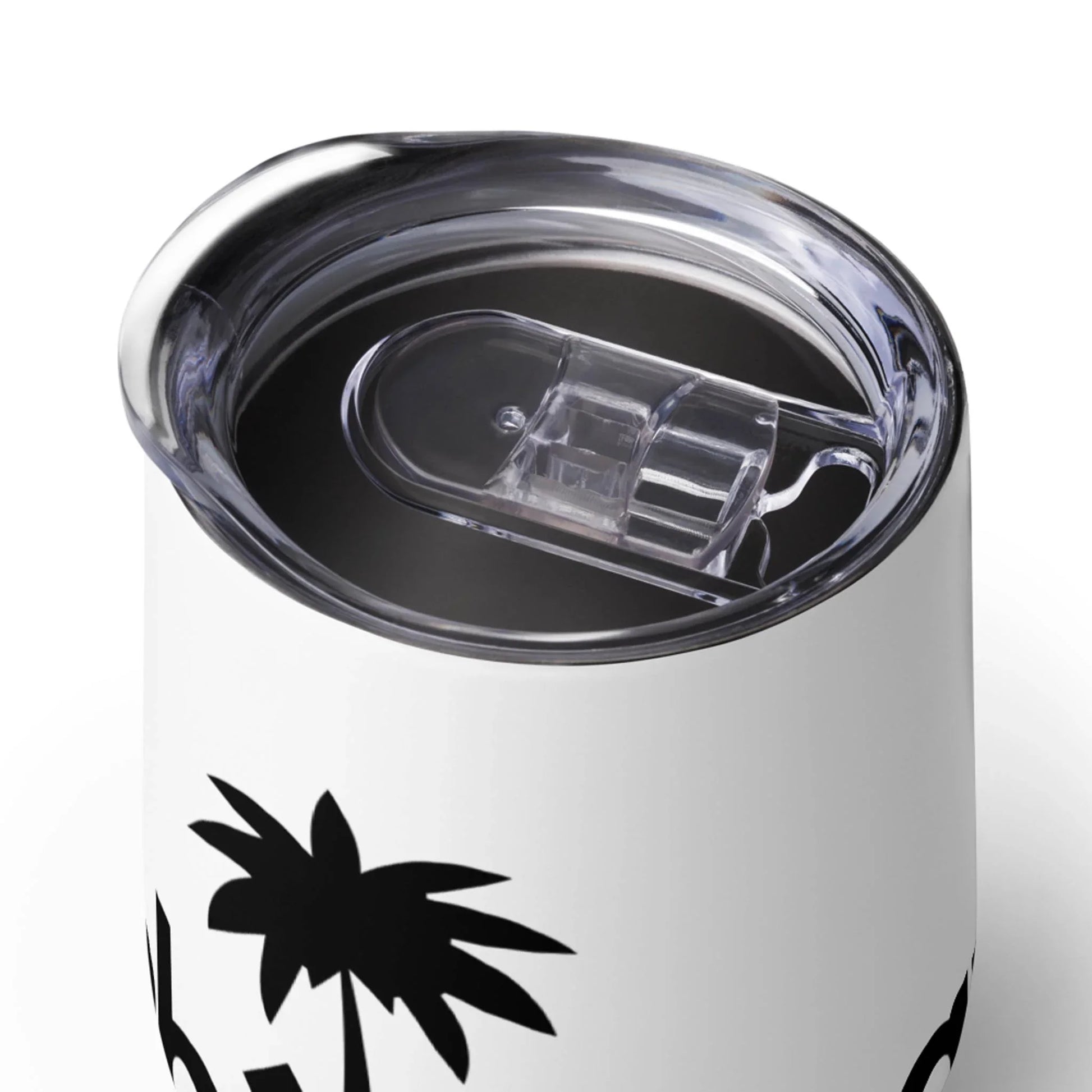 A close-up of a white Mambí travel mug with a clear plastic lid. The mug features a black palm tree design and is filled with a dark beverage.