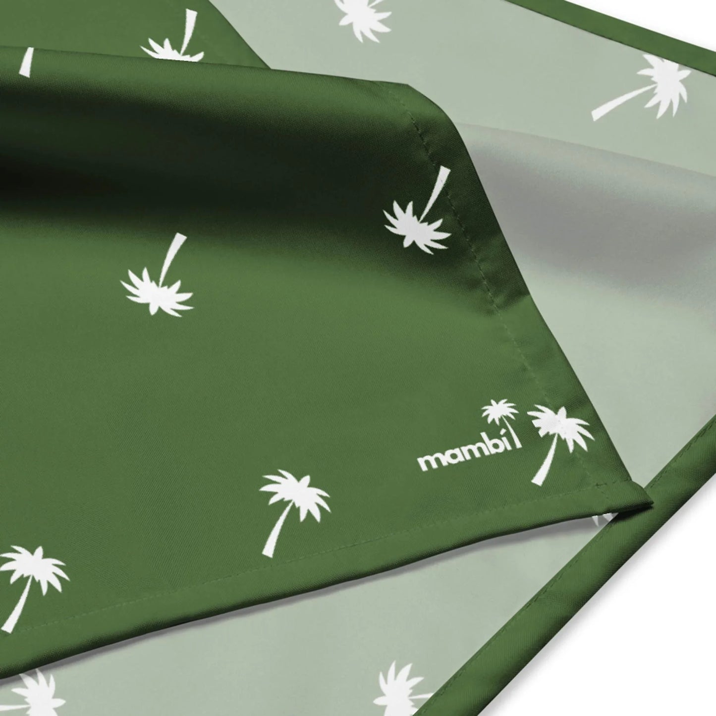 A green and light gray fabric with white palm tree silhouettes and the word Mambí printed on it, showing both sides of the material.