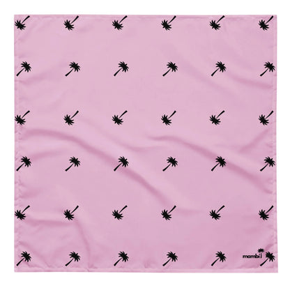 A pink square cloth featuring a repeating pattern of small black palm trees, with the word Mambí and a palm tree logo in the bottom right corner.