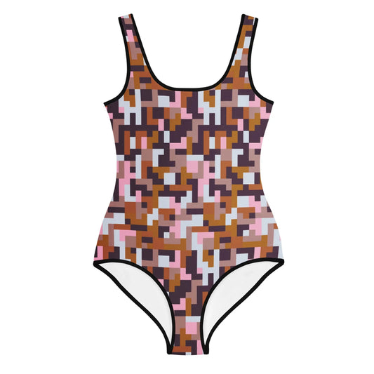 The Printful Pixie One-Piece Swimsuit for big kids and teens features a brown, pink, black, and white pixelated geometric design with black trim and UPF 50 for stylish sun protection.