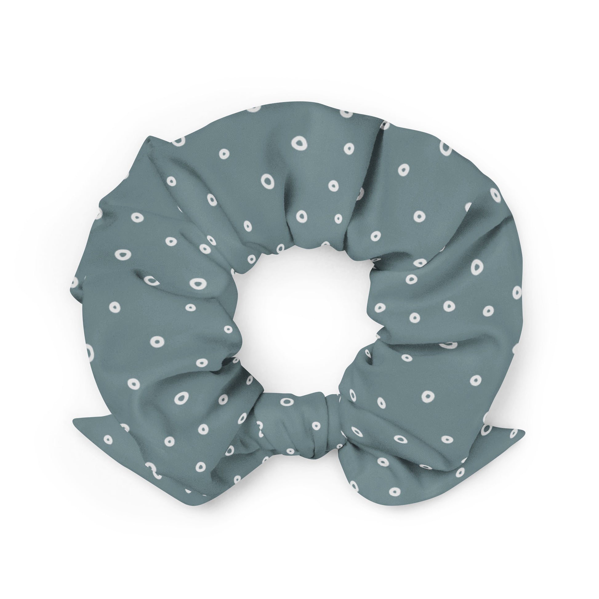 A gray-blue recycled polyester scrunchie with a bow, decorated with a pattern of small white circles evenly spaced across the fabric—a stylish and eco-friendly hair accessory.