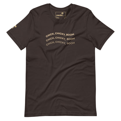 A brown fitted shirt crafted from comfy cotton, featuring CHICK, CHICKY, BOOM in gold curved lines across the chest and a small gold palm tree on the left sleeve—ideal for fans of unique graphic tees.