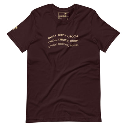 An oxblood black fitted cotton shirt featuring the phrase CHICK, CHICKY, BOOM in beige curved text repeated thrice across the chest and a small gold palm tree on the left sleeve—ideal for fans of playful graphic tees.