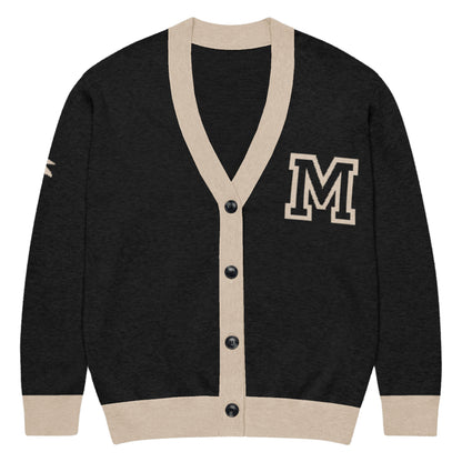 A unisex black & taupe cardigan with beige trim, featuring a large taupe letter M on the left chest and a taupe patch on the right sleeve. This jacquard knit has a V-neck and five black front buttons.