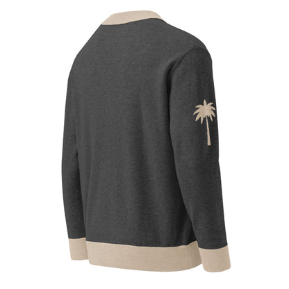 A dark gray two-tone cardigan with beige collar, cuffs, and hem, featuring a beige palm tree graphic on the left sleeve. The cardigan is displayed from the back.