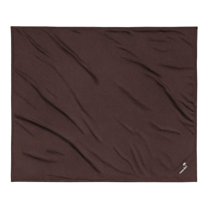 A flat, brown fleece blanket with slight wrinkles, featuring a small white embroidered logo in one corner on a plain white background.