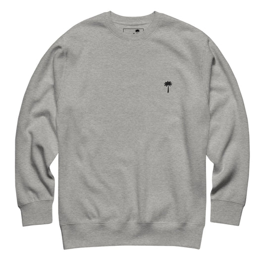 A plain light gray Mambí crewneck sweatshirt with a small black palm tree logo on the left chest area. The sweatshirt features long sleeves with ribbed cuffs and hem.