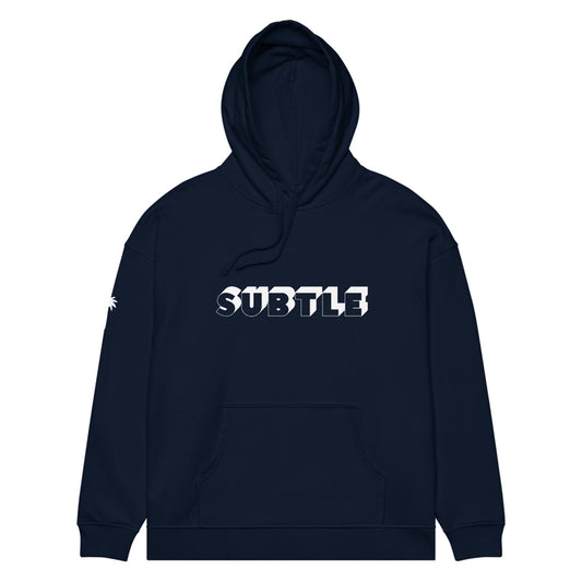 A navy blue hoodie with a front pocket and hood, featuring the word SUBTLE in bold white and gray 3D letters across the chest. A small Mambí graphic in white appears on the left sleeve.