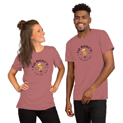 Two people wearing matching dusty pink t-shirts with a Tio Rickys Cuban Craft Beer logo and a subtle Mambí touch. They are smiling and standing side by side, bodies slightly turned toward each other.