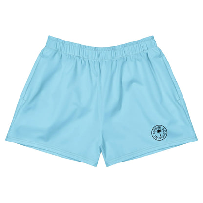 Light blue Mambí athletic shorts with an elastic waistband and a small circular black logo on the lower left leg. The shorts are laid flat against a white background.